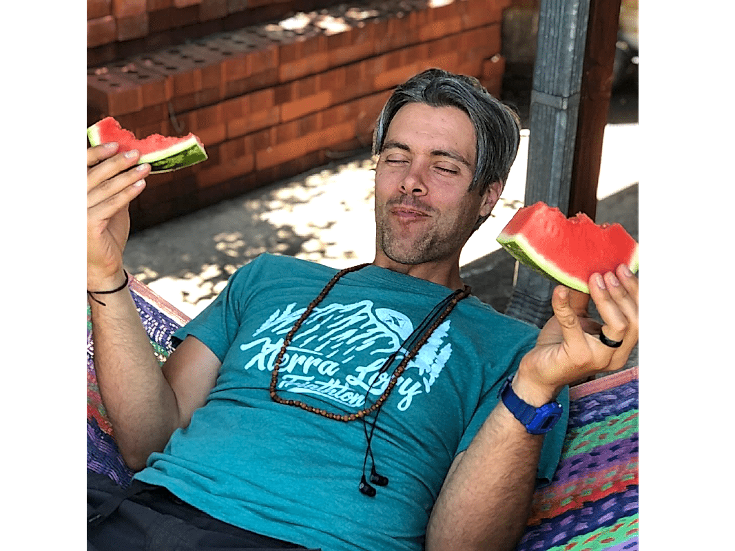 Photo of Austin eating watermelon on a hammock