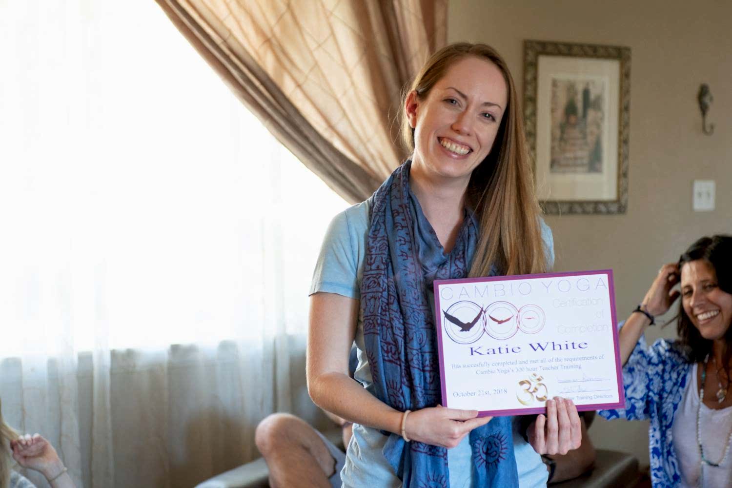 Photo of Katie holding her YTT certificate